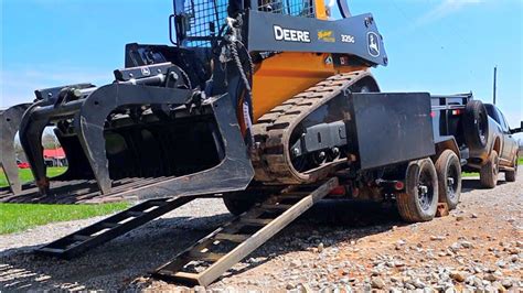 loading skid steer in back of dump truck|bobcat skid steer loading.